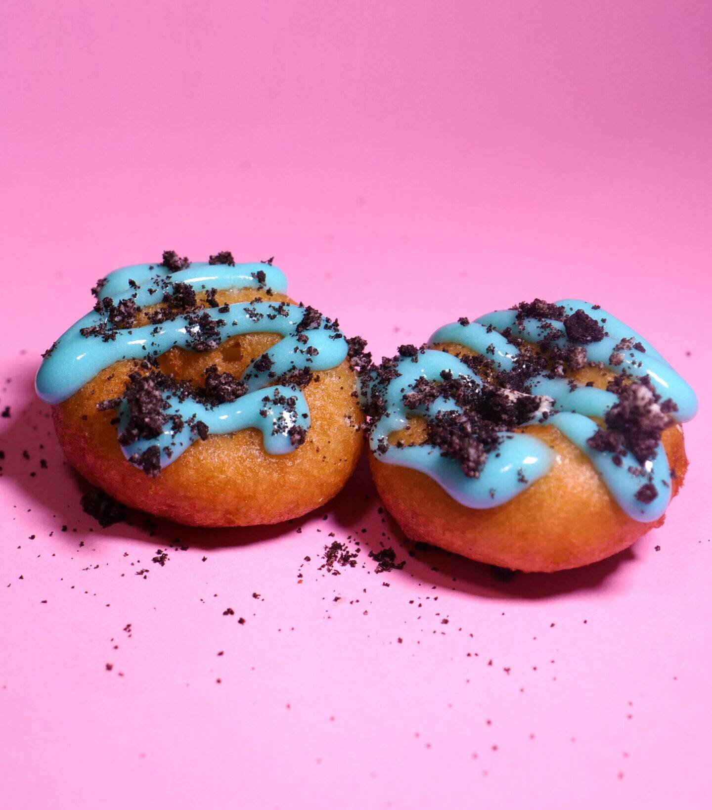 Blue Oreo mini donuts on a pink background